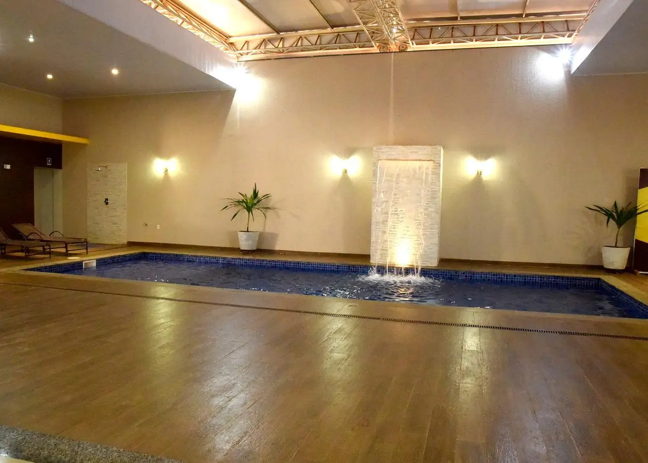 Piscina interna do Hotel Lirius com cascata decorativa