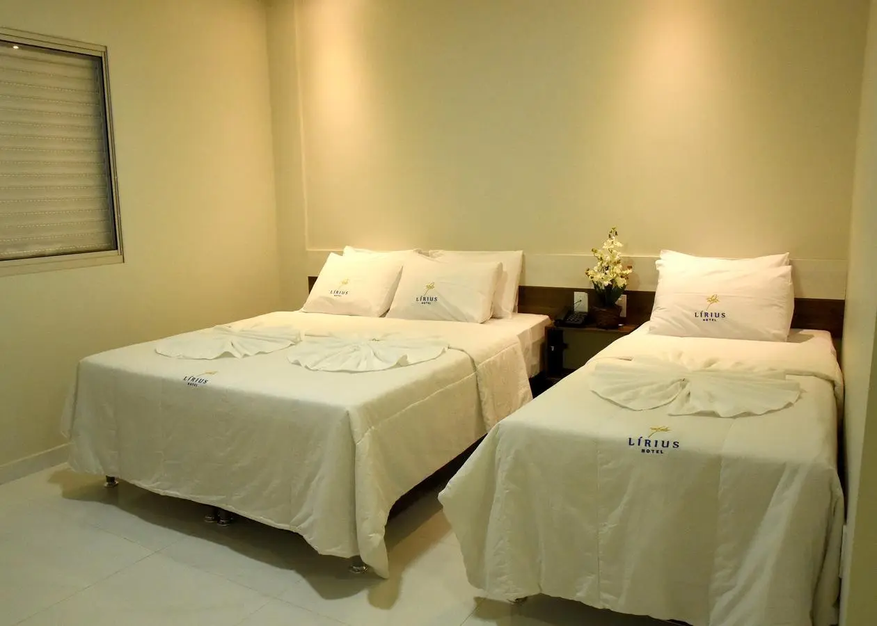 Acomodação com cama de casal e cama de solteiro no Hotel Lirius